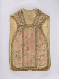 Chasuble, liturgical vestment;, noted. A large floral pattern and lace motif are set against a