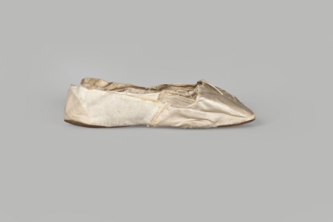 Flat women's slippers of white satin, ca. 1836. Flat-cut toe, symmetrical thin leather soles.