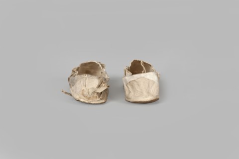 Flat women's slippers of white satin. Flat-cut toe, symmetrical soles of thin leather. The endpaper