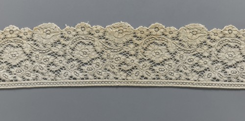 Lace fragment, machine-made lace; strip serrated on one side following the forms of rosettes and