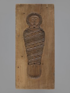 Double-sided gingerbread mold. Obverse: baby in swaddling clothes richly decorated with various