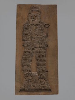 Double-sided gingerbread mould. Obverse: figure of a bearded man playing a horn; reverse: several