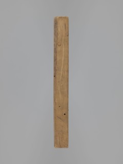 Double-sided gingerbread form. Oblong rectangular shape; obverse: female figure in a long patterned