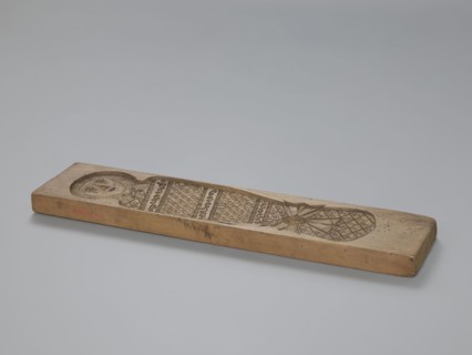 Double-sided gingerbread mold. Obverse: baby in swaddling clothes richly decorated with various