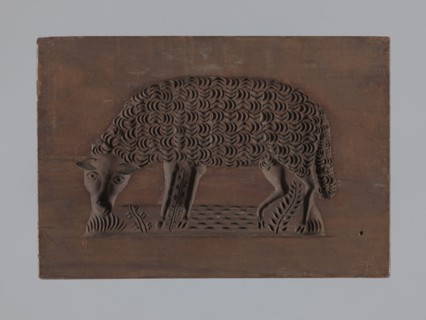Double-sided gingerbread form; rectangular shape. One side: image of a sheep grazing in a meadow.