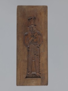 Double-sided gingerbread mould. Side A: figure of a soldier; Side B: various floral and geometric