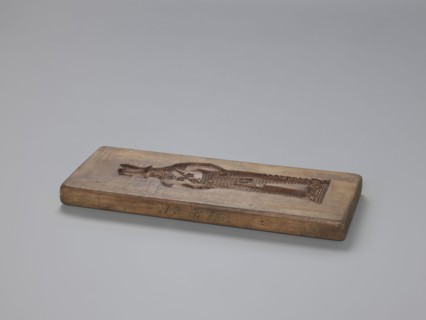 Double-sided gingerbread mould. Side A: figure of a soldier. Side B: various floral and geometric