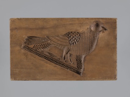 Double-sided gingerbread mold. Obverse: male figure in a high hat and fur-lined jacket sitting on a
