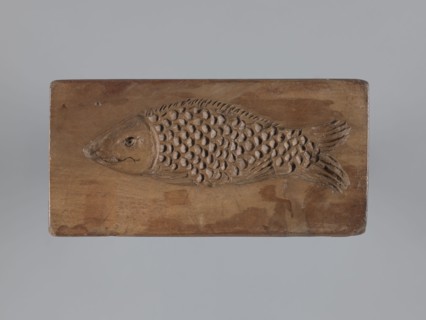 Double-sided gingerbread mould. Obverse: stylised elongated fish covered with scales, shown in