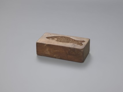 Double-sided gingerbread mould; obverse: stylised elongated fish covered with scales, shown in