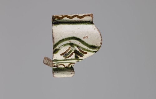 Cornice tile fragments 4, painted with a wavy twirl pattern; tile cullet; stoves; plant