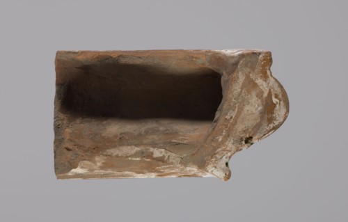 Cornice tile fragments 4, painted with a wavy twirl pattern; tile cullet; stoves; plant
