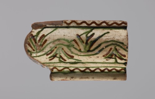 Cornice tile fragments 4, painted with a wavy twirl pattern; tile cullet; stoves; plant