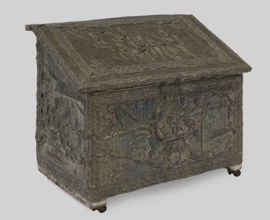 Box with straight walls and a diagonally sloping lid, covered with embossed brass sheet depicting
