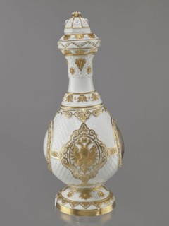 Bottle-shaped vase with a domed lid. Embossed and colorfully painted decoration. Four medallions