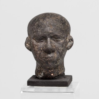 Head of a priest figurine, Male Egyptian sculptural fragment: a man's head, completely devoid of