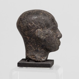 Head of a priest figurine, A man's head, fragment of a statuette, completely devoid of hair. Skull