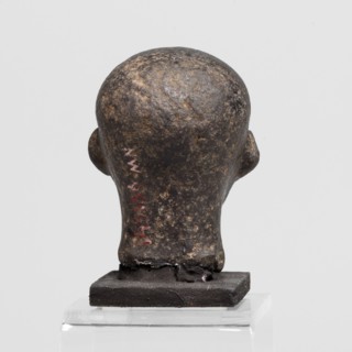Head of a priest figurine. A man's head fragment of a statuette, completely devoid of hair. Skull