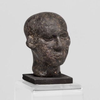 Head of a priest figurine, A man's head fragment of a statuette, completely devoid of hair.