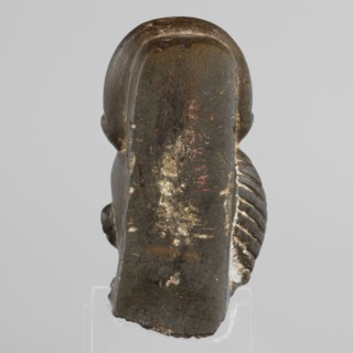 Fragment of a figurine of the god Khonsu — head with a lock of youth and a disc mounted on a