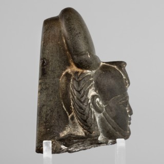 Fragment of a figurine of the god Khonsu — head with a lock of youth and a disc mounted on a