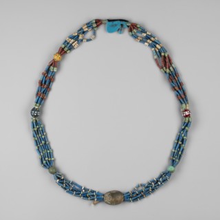 Necklace with a scarab and an udjat eye. Necklace composed of six rows of faience tubular and
