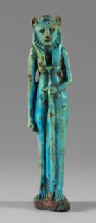 Amulet — figurine of a lion-headed goddess. A lion-headed goddess, in a tripartite wig and a narrow