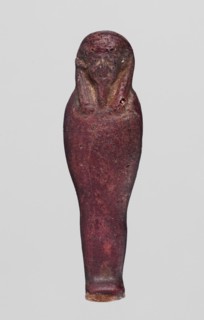 Amulet - mummy-shaped figurine;, Mummy-shaped figurine, back smooth; dark red glass; Ptolemaic