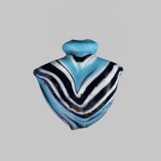 Amulet in the shape of a heart ib, made of blue glass decorated with parallel lines forming a