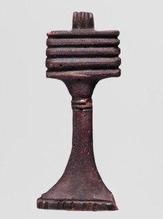 Amulet - djed pillar, A brown glass amulet in the shape of a djed pillar with five crossbars and a