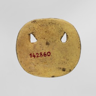 Amulet — plaque with the head of the god Bes. Amulet in the form of an oval, serrated, openwork