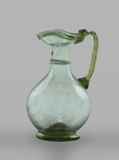 Oinochoe, Transparent, light green glass. Spherical belly on a foot with a clearance, created by
