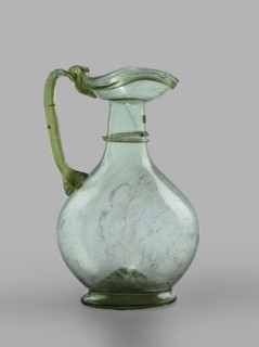 Oinochoe. Transparent, light green glass. Spherical belly on a foot with a clearance, created by