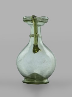 Oinochoe, Transparent, light green glass. Spherical belly on a foot with a clearance, created by