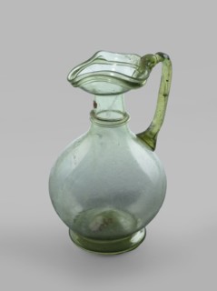 Oinochoe. Transparent, light green glass. Spherical belly on a foot with a clearance, created by