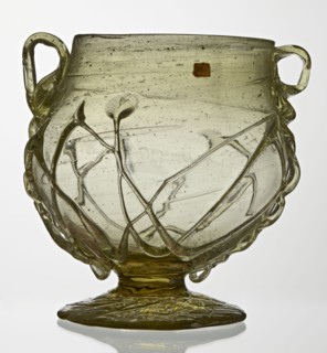 Skyphos, deep bowl with wide foot and two small vertical handles. Surface decorated with a zigzag