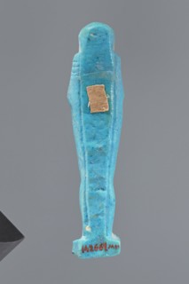 Ushabti, Mummy-shaped figurine standing on a base, back supported by a pillar/pilaster. Arms
