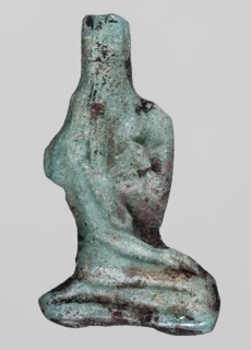 Amulet — seated goddess Isis; light blue glass; right hand raised to forehead, left hand lowered to