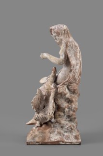 Figurine of Leda with a Swan, A woman sits on a rock and feeds a swan standing next to her. She is