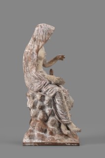 Figurine of Leda with a Swan, A woman sits on a rock and feeds a swan standing next to her. She is
