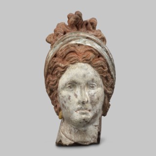 Head of a woman. Female head, fragment of a larger figurine. The head is tilted slightly to the