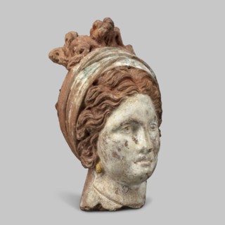 Head of a woman. Female head, fragment of a larger figurine. The head is tilted slightly to the