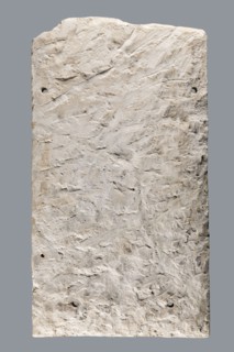 Small limestone stele with simple architectural decoration. Recessed epigraphic field surrounded by