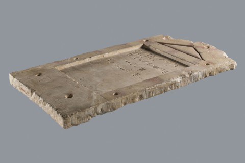 Small limestone stele with simple architectural decoration. Recessed epigraphic field surrounded by