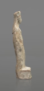 Female terracotta figurine of a standing woman, depicted frontally. Set on a small, hollow,