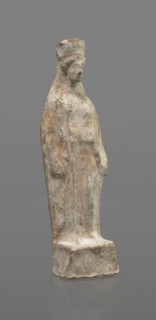 Female figurine, terracotta, figurine of a standing woman depicted frontally. Set on a small,
