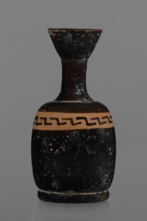 Black-finned aryballois lekythos. Large, ring-shaped foot. Body squat, barrel-shaped with rounded