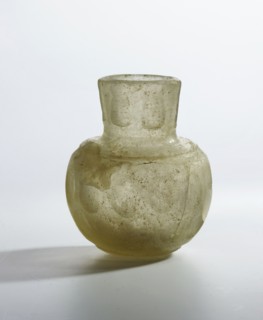 Bottle, glass with flattened bottom, rounded shoulders merging into a cylindrical neck decorated