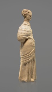 Terracotta figurine of a standing woman. Terracotta, molded figurine, Tanagra figurine. Figurine of