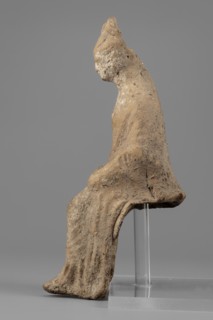 Female figurine. Female figure in a seated position, slightly leaning forward. The back of the